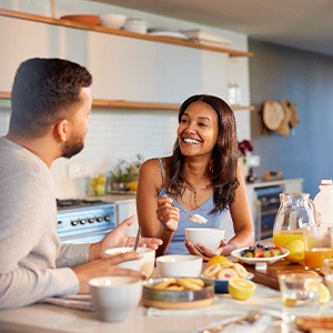 Couple smiling while enjoying meal at home