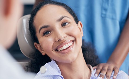 a patient smiling while visiting her dentist